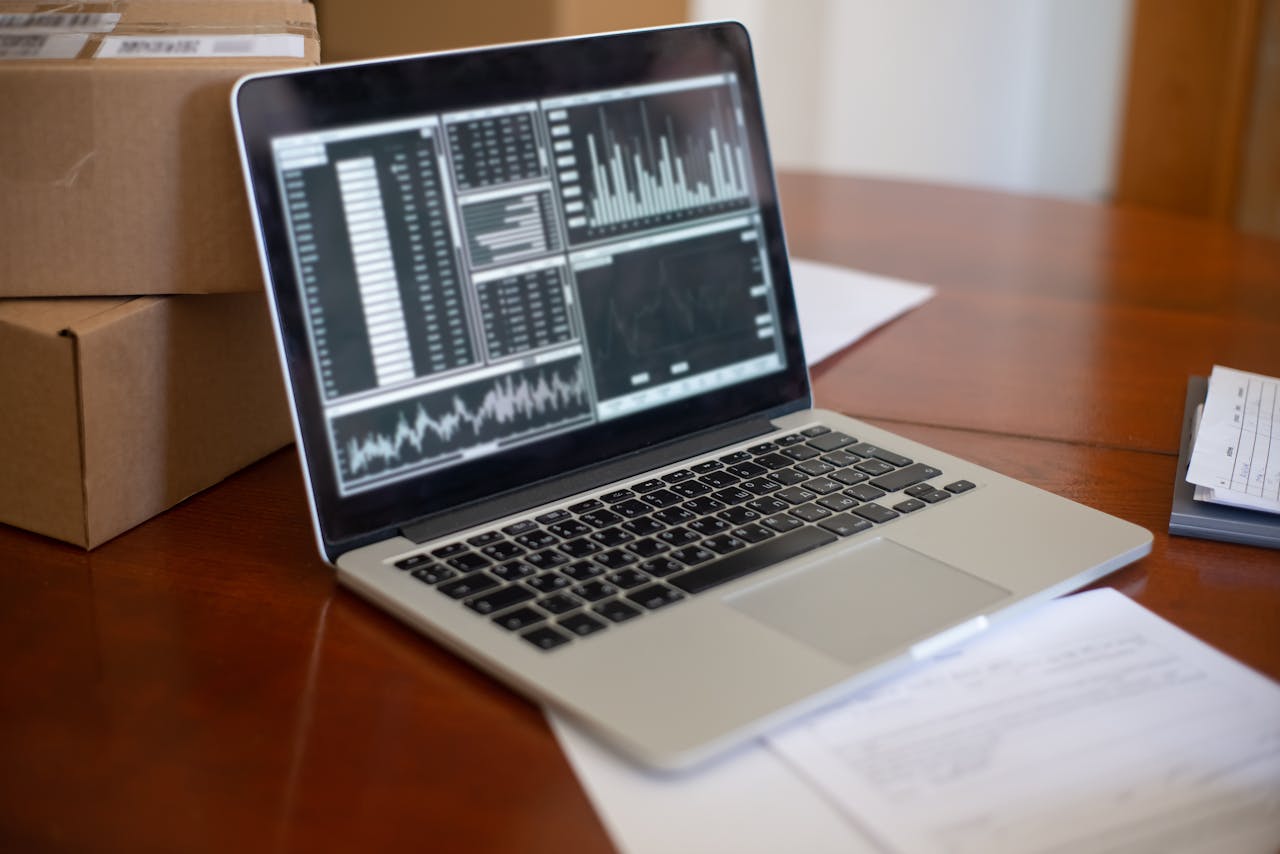 Mastering the First Impression: Your intriguing post title goes here Laptop showing data graphs on wooden table with cardboard boxes, depicting a small business office setting.